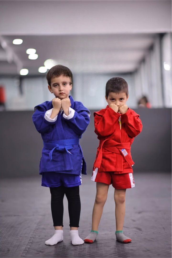 Mavi ve kırmızı sambo ceketli iki küçük sporcu